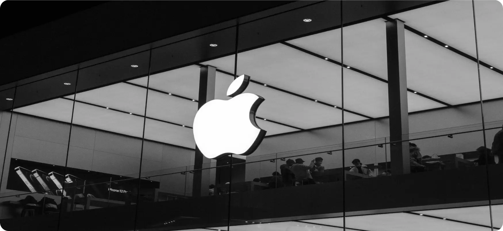 Illuminated Apple logo inside a glass-walled store