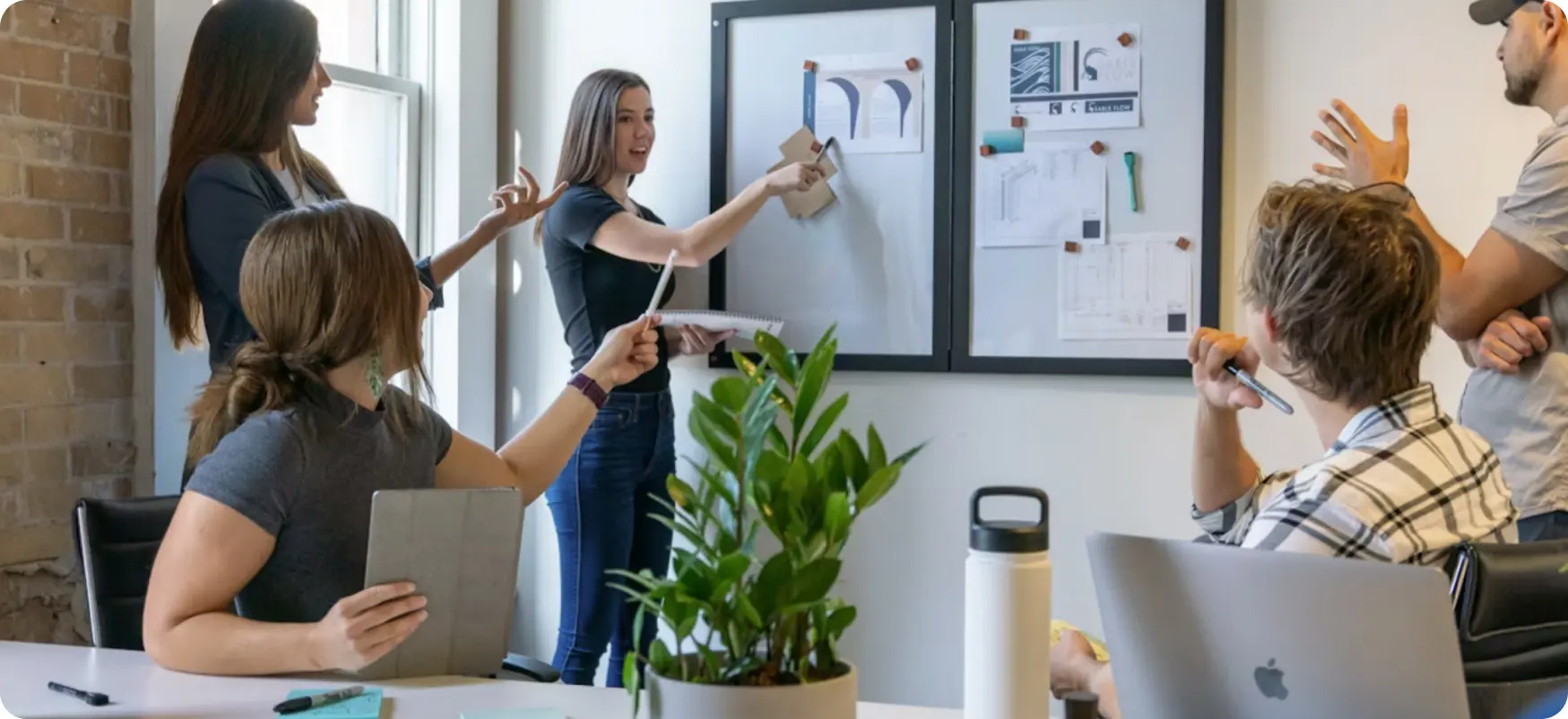 A creative team reviewing sketches pinned to a board